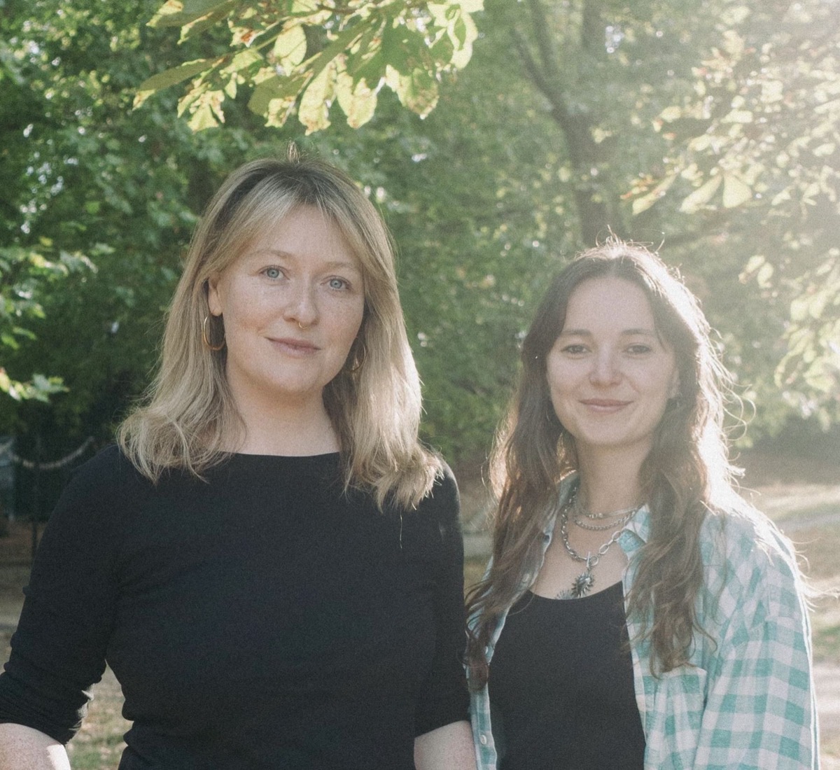 Ilka and Emma standing together outdoors under a tree